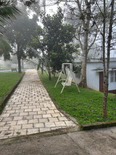 a park with a swing set in the grass at Mahogany by Exuberance Stays in Wayanad