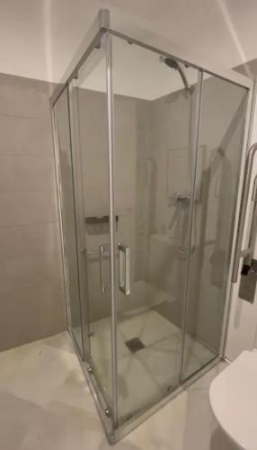 a glass shower enclosure in a bathroom with a sink at Apartamentos GADIR CENTRO in Cádiz