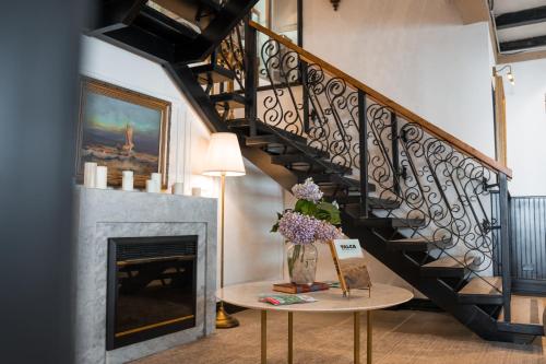 a staircase with a vase of flowers on a table next to a fireplace at Hotel Marcos Gamero in Talca