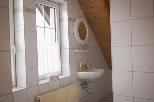 a bathroom with a sink and a mirror and a window at B&B Talstation Ferienwohnung für 2 Personen in Hörselberg-Hainich