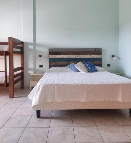 a bedroom with a large bed with blue pillows at Baja Azzurra in Bari Sardo