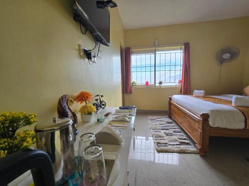 a bedroom with a bed and a kitchen with a sink at Kodai Hillscape in Kodaikānāl