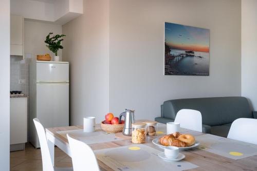 a kitchen with a table with a plate of food on it at Club del Sole Stork Family Collection in Giulianova