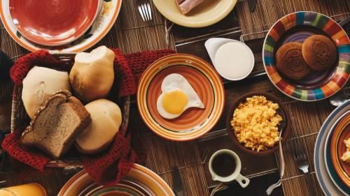 a table topped with plates of eggs and bread at Pousada Vila do Patacho in Pôrto de Pedras