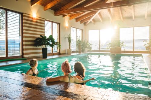 three girls sitting in a swimming pool at Wellness Pension Waldhof in Sankt Georgen