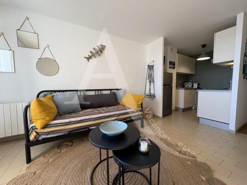un salon avec un canapé et deux tables dans l'établissement T3 moderne, vue mer et parking, à Sète