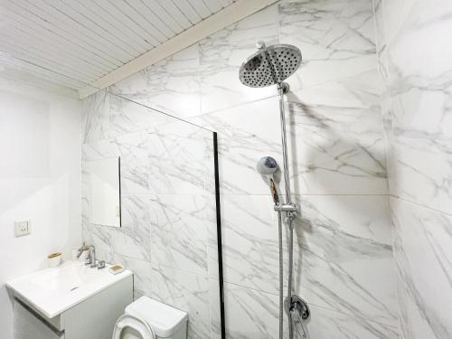 a white bathroom with a shower and a toilet at Casa Iguazú 121 in Puerto Iguazú