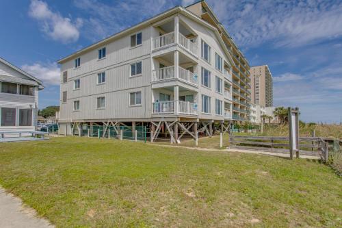 a large apartment building with a lawn in front of it at Oceanfront North Myrtle Beach Condo with Patio! in Myrtle Beach