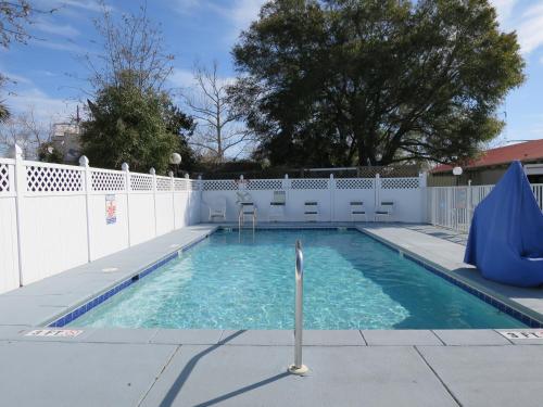 a swimming pool next to a white fence at Executive Inn - Panama City Beach in Panama City Beach