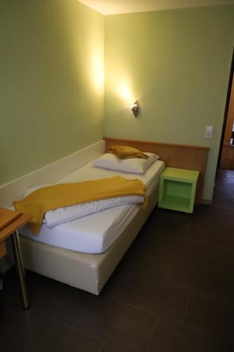 a small bedroom with a bed in a room at Hotel Hohe Wart in Herbrechtingen