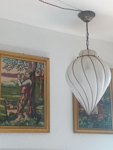 a chandelier hanging from a ceiling next to a painting at Villa Erbetta in Guardabosone