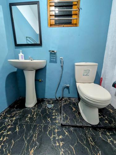 Un baño con un inodoro blanco y un lavabo. en Costels Hiriketiya, en Hiriketiya