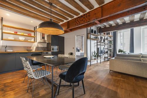 une cuisine et une salle à manger avec une table et des chaises dans l'établissement Ghost, à Paris