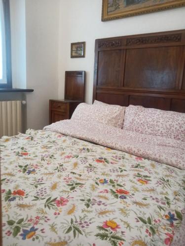 a bedroom with a bed with a floral bedspread at Villa Erbetta in Guardabosone