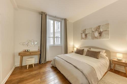 ein weißes Schlafzimmer mit einem Bett und einem Fenster in der Unterkunft Arc & Luxe Champs-Elysées in Paris