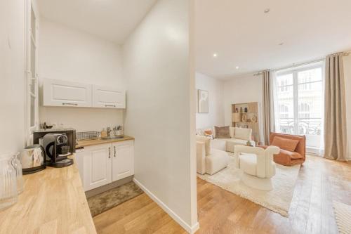 Il dispose d'une cuisine et d'un salon avec un mobilier blanc. dans l'établissement Arc & Luxe Champs-Elysées, à Paris