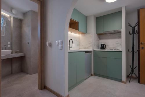 a kitchen with green cabinets and a sink at City Vibe Center Family Flat 3 in Thessaloniki