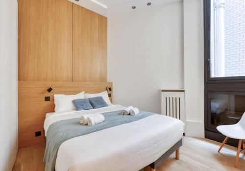 - une chambre avec un grand lit et une cheminée dans l'établissement Cosy 2 Rooms Flat - Chic 16th district - Mid-term, à Paris