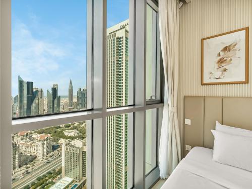 a bedroom with a window with a view of the city at Brand New! Downtown views located on Dubai Mall in Dubai