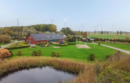 an aerial view of a red barn and a pond at 2 Bedroom Beautiful Home In Wagenborgen in Wagenborgen