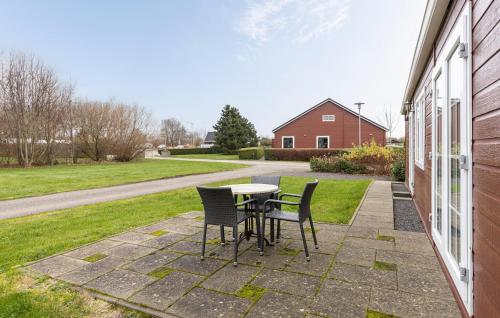 a patio with two chairs and a table on the side of a house at 2 Bedroom Beautiful Home In Wagenborgen in Wagenborgen