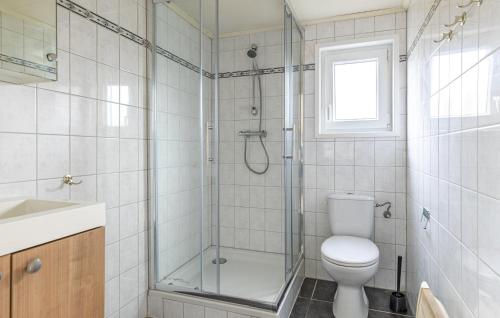 a bathroom with a toilet and a glass shower at 2 Bedroom Beautiful Home In Wagenborgen in Wagenborgen