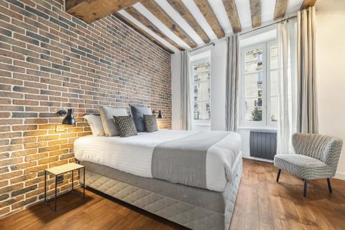 Un dormitorio con una cama y una pared de ladrillo. en Ghost, en París