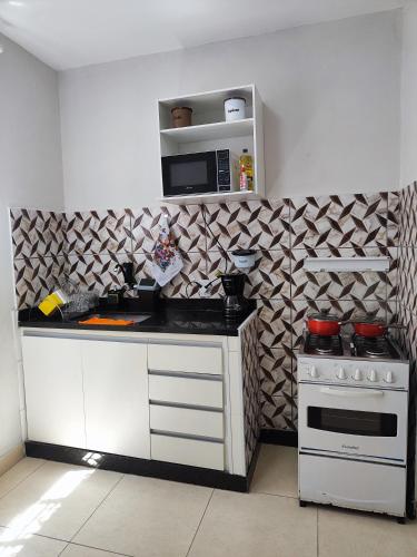 a kitchen with a stove and a microwave at kitNet mobiliada de 1 quarto in Contagem