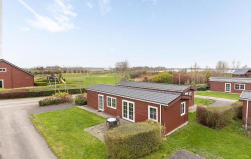 a small red house with a yard and a driveway at Cozy Home In Wagenborgen With Wifi in Wagenborgen