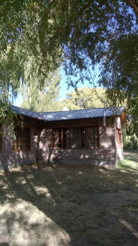 ロデオにあるCabañas Zorzal Rodeoの木の下に座る小さな石造りの家