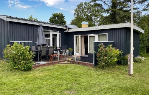 a grey house with a patio and a yard at Stunning Home In Frørup With Wifi in Frørup