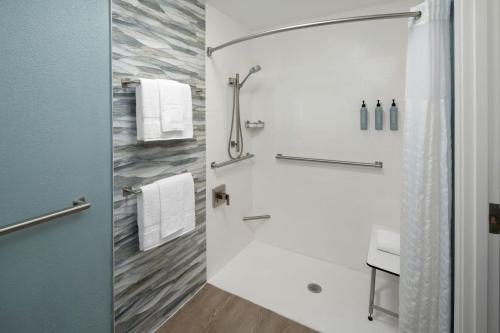 a bathroom with a shower with a toilet and a sink at Courtyard Charleston Waterfront in Charleston