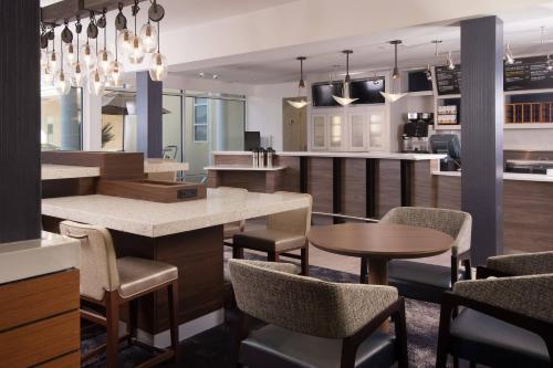 a restaurant with tables and chairs and a bar at Courtyard Charleston Waterfront in Charleston
