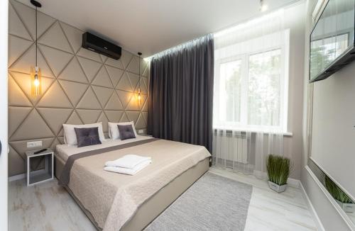 a bedroom with a large bed and a television at Pechersky Kvartal Apartments in Kyiv