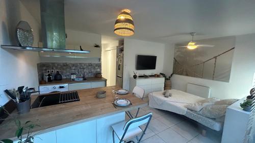 une cuisine et un salon avec une table et un canapé dans l'établissement Mer & Nature - Le Ponant, à La Grande Motte