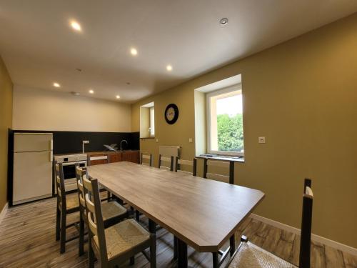 a kitchen and dining room with a wooden table and chairs at Gîte 43 - Le Saint André in Saint-André-de-Chalencon