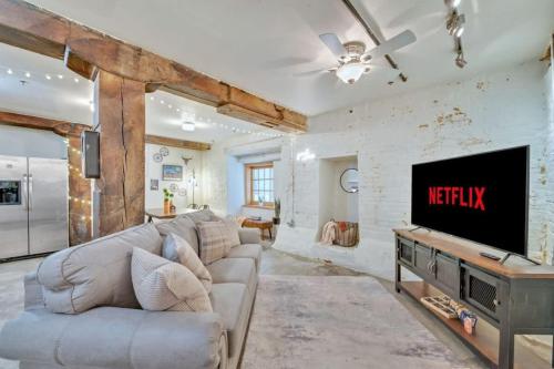 a living room with a couch and a tv at Chic Downtown Condo in Knoxville's Old City in Knoxville