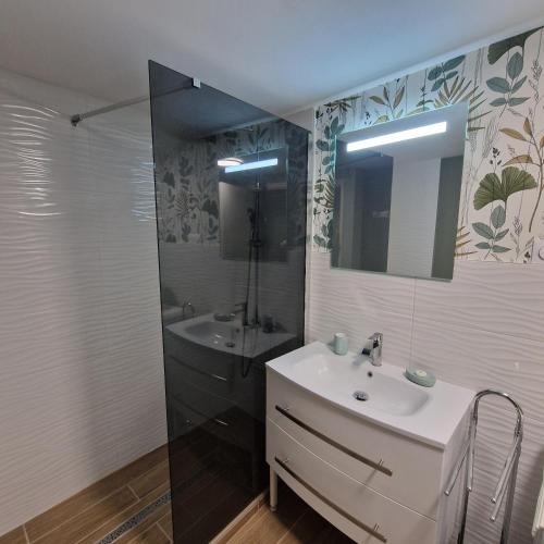 une salle de bain avec un lavabo, un miroir et une baignoire dans l'établissement gite les gardes, à Saint-Pierre-de-Côle