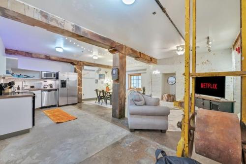 a living room with a couch and a kitchen at Chic Downtown Condo in Knoxville's Old City in Knoxville