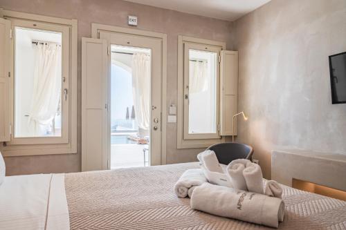 a bedroom with a bed with towels on it at Apeiron Blue Santorini - Sustainable Adults Only 14 Plus in Fira
