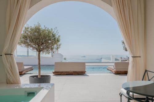a view of a pool from a room with a large window at Apeiron Blue Santorini - Sustainable Adults Only 14 Plus in Fira