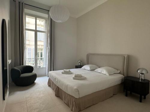 une chambre avec un lit, une chaise et une fenêtre dans l'établissement Appartement Centre Cannes, à Cannes
