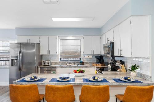 una grande cucina con mobili bianchi e un tavolo con sedie di Outdoor Games, Firepit, King bed, BBQ Grill, Close to Downtown and attractions a Tampa