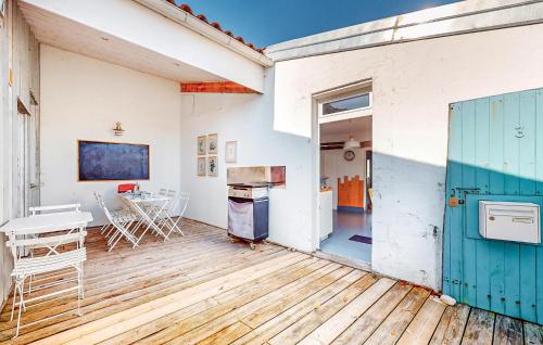 an open kitchen and dining room with a blue door at Gorgeous Home In Saint-Denis-D'oléron in Saint-Denis-dʼOléron