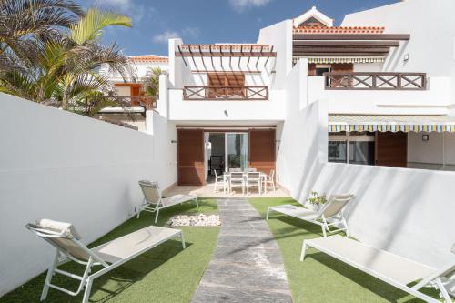 a white house with chairs and a patio at Villa in Parque Santiago III in Playa de las Americas