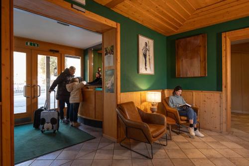 a woman sitting in a chair in a room at Hotel Bellamonte in Predazzo