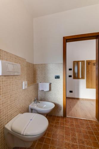a bathroom with a toilet and a sink at Hotel Bellamonte in Predazzo