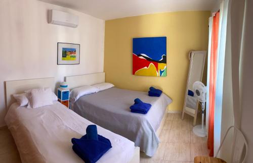 two beds in a room with blue pillows on them at Villa Primera in Playa Blanca
