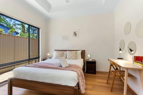 a bedroom with a bed and a desk and a window at Beachside Gem in Doubleview, Free Wi-Fi, Parking in Perth