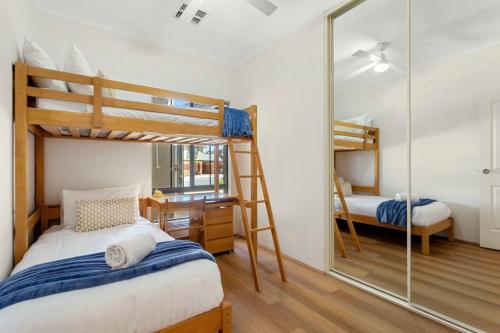 a bedroom with two bunk beds and a mirror at Beachside Gem in Doubleview, Free Wi-Fi, Parking in Perth